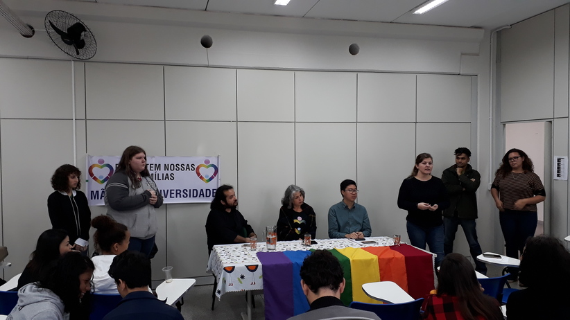 Professora Nadia Sabchuk em pé proferindo discurso de agradecimento aos palestrantes convidados no evento de combate à homofobia no ambiente escolar