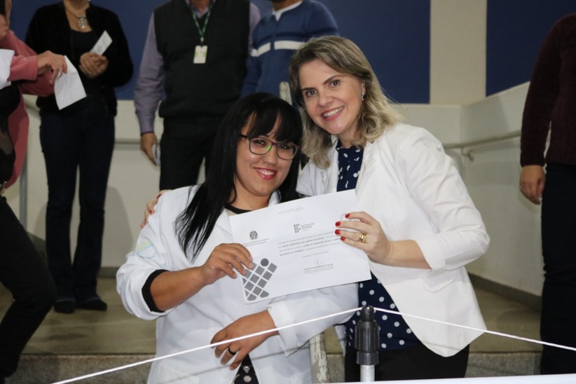 Professora Adriana Gallo entregando certificado de conclusão do curso FIC Balconista de Farmácia para estudante