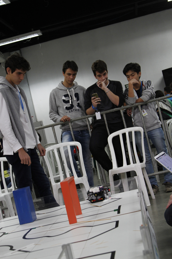 Integrantes da equipe posam para a foto segurando um robô de Lego que eles programaram para a OBR