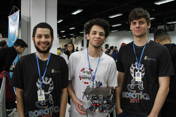 Os integrantes da equipe posam para a foto segurando um robô de Lego
