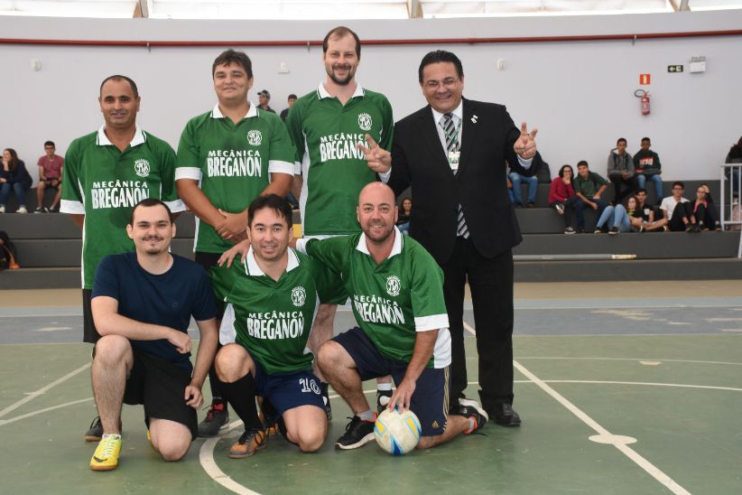 Foto de uma quadra com pessoas posicionadas como um time de futebol com reitor à direita