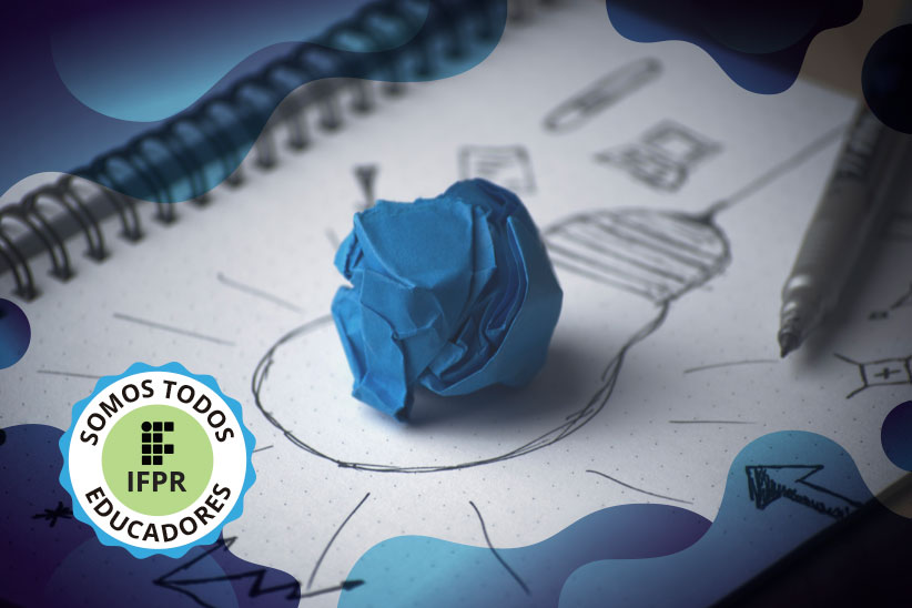 Imagem ilustrativa colorida que mostra um caderno aberto. Em uma das folhas, há uma lâmpada desenhada. Sobre o desenho, está uma folha de papel azul amassada.
