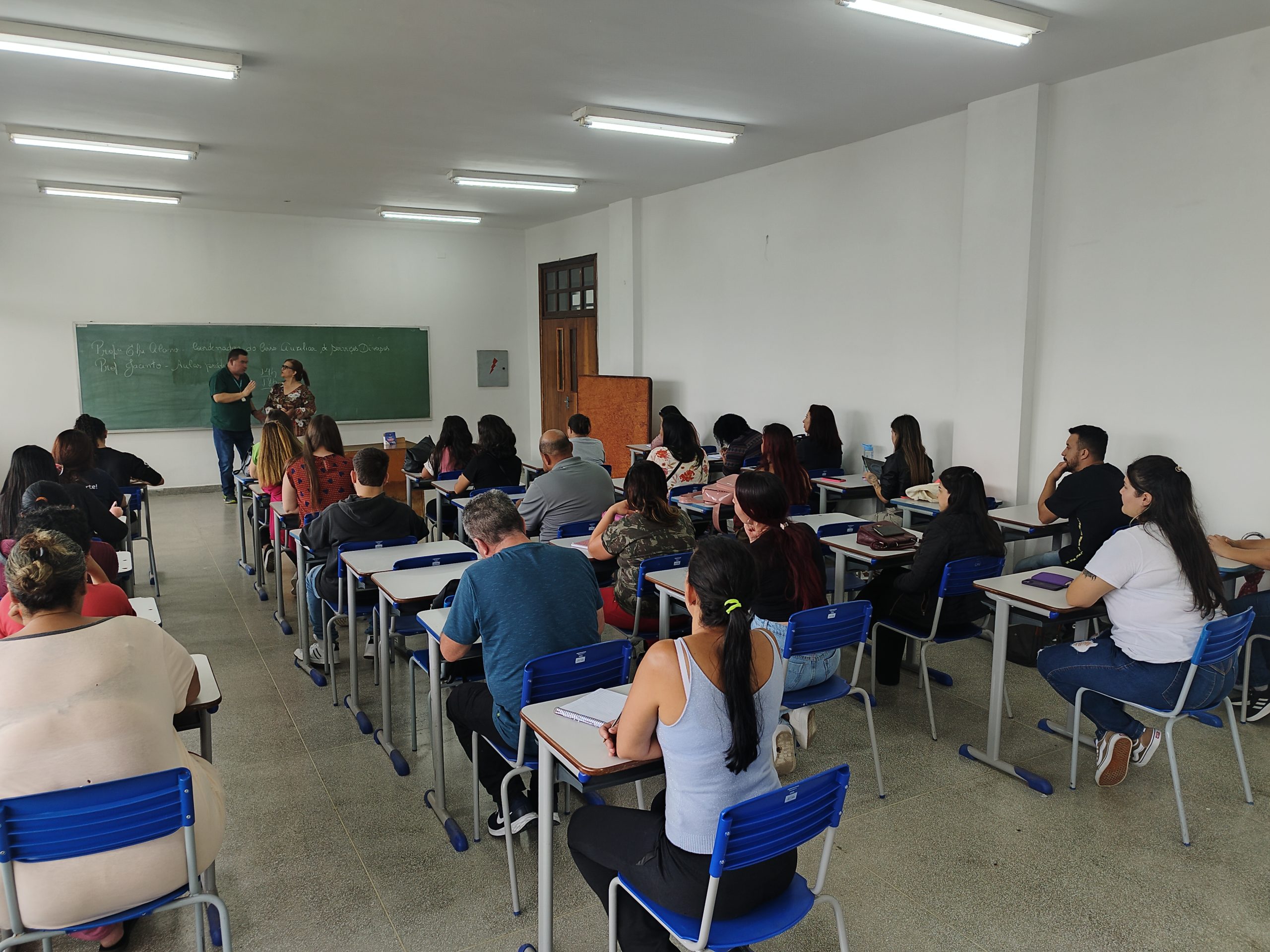 Aqui está uma descrição para o atributo alt da imagem: “Alunos do Programa Autonomia e Renda Petrobras do IFPR assistem a uma aula em sala com fileiras de carteiras. Dois instrutores estão em pé na frente, próximos ao quadro, orientando os estudantes.”